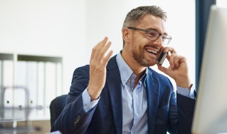 Service-Mitarbeiter telefoniert an seinem Schreibtisch – Deutsche Assistance 